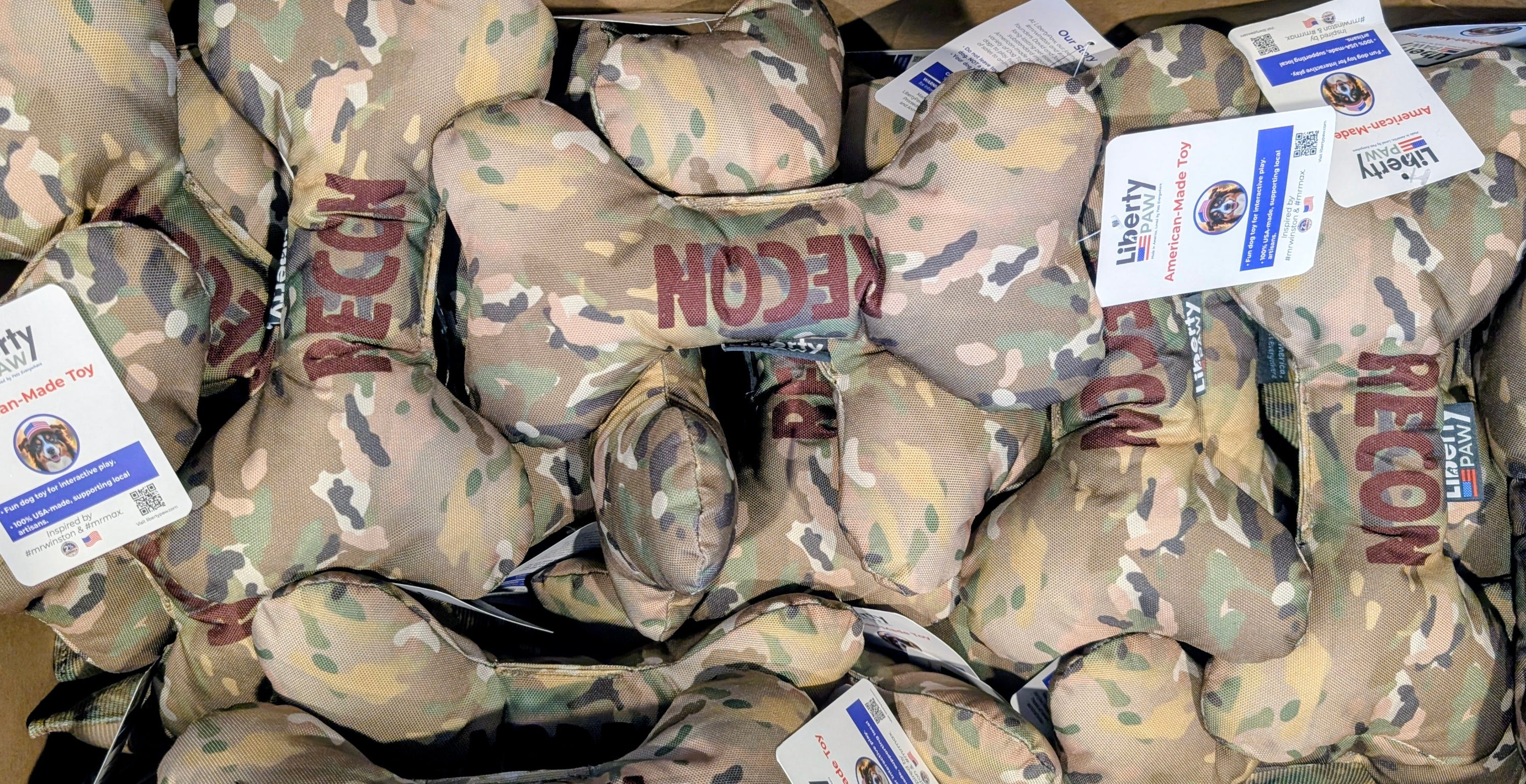 multiple Camouflage dog bone toys with 'RECON' branding and visible tags on a black background