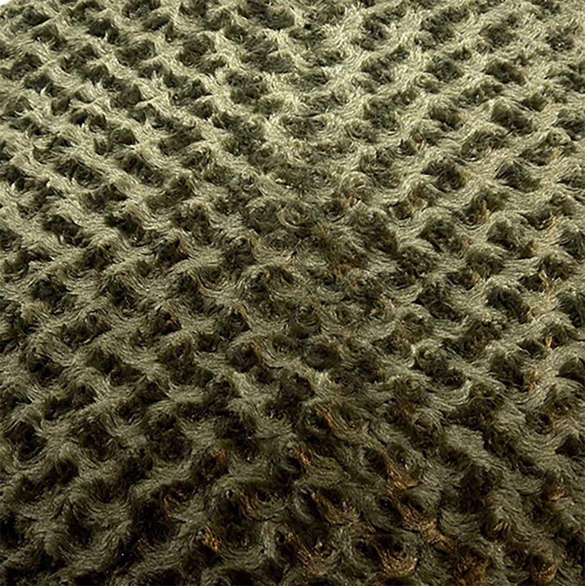 Close-up of olive green swirl plush fabric on a dog bed