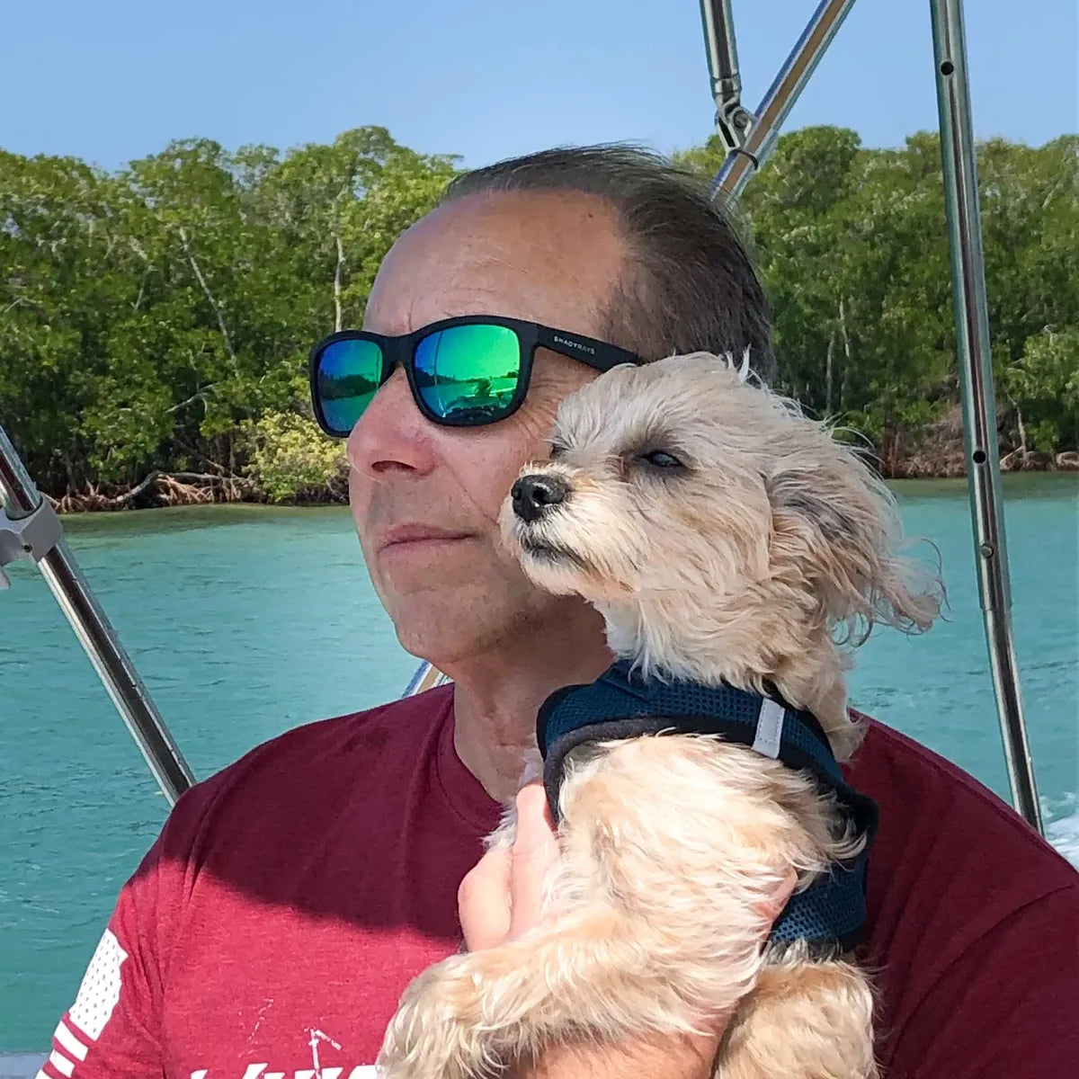 Dr. David M. Spitz, LibertyPaw founder, on a boat in Florida holding Winston, his Morkie and LibertyPaw's chief product tester