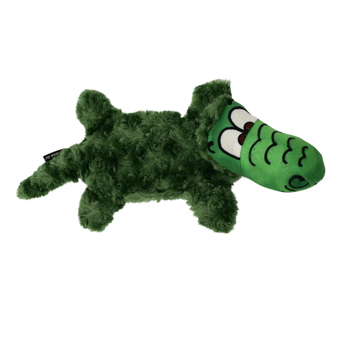 Side view of a green plush alligator dog toy with a long fuzzy body and smiling snout